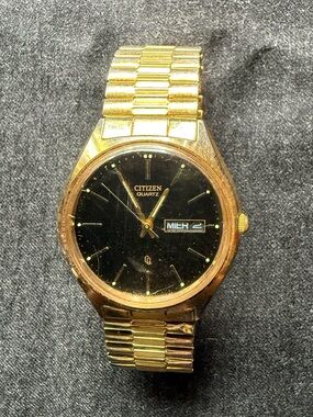 Vintage Citizen Quartz Watch with black dial gold tone case and flex band.